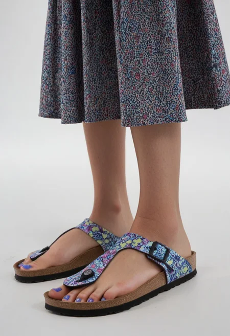 1girl, solo, simple_background, white_background, gizehonfeet, blue_toenail_polish, close-up, lower_body, footwear_focus, patterned, long_skirt