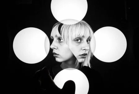 d1g1cam, Multiple fragmented facial features, black white artistic portrait, circular spotlight effects, repeated eyes lips patterns, dark background, surreal composition, overlapping facial elements, kaleidoscopic arrangement, dramatic contrast lighting, bangs hair details visible, experimental photography technique, abstract portrait style, floating facial fragments, film grain texture, high contrast monochrome processing, artistic double exposure effect, avant-garde portrait composition