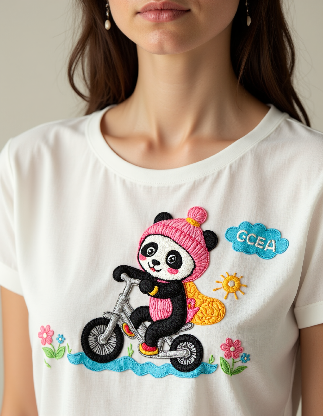 aplqueCE_style. a woman wearing a t-shirt with a colorful applique of a cute panda driving a tricycle.