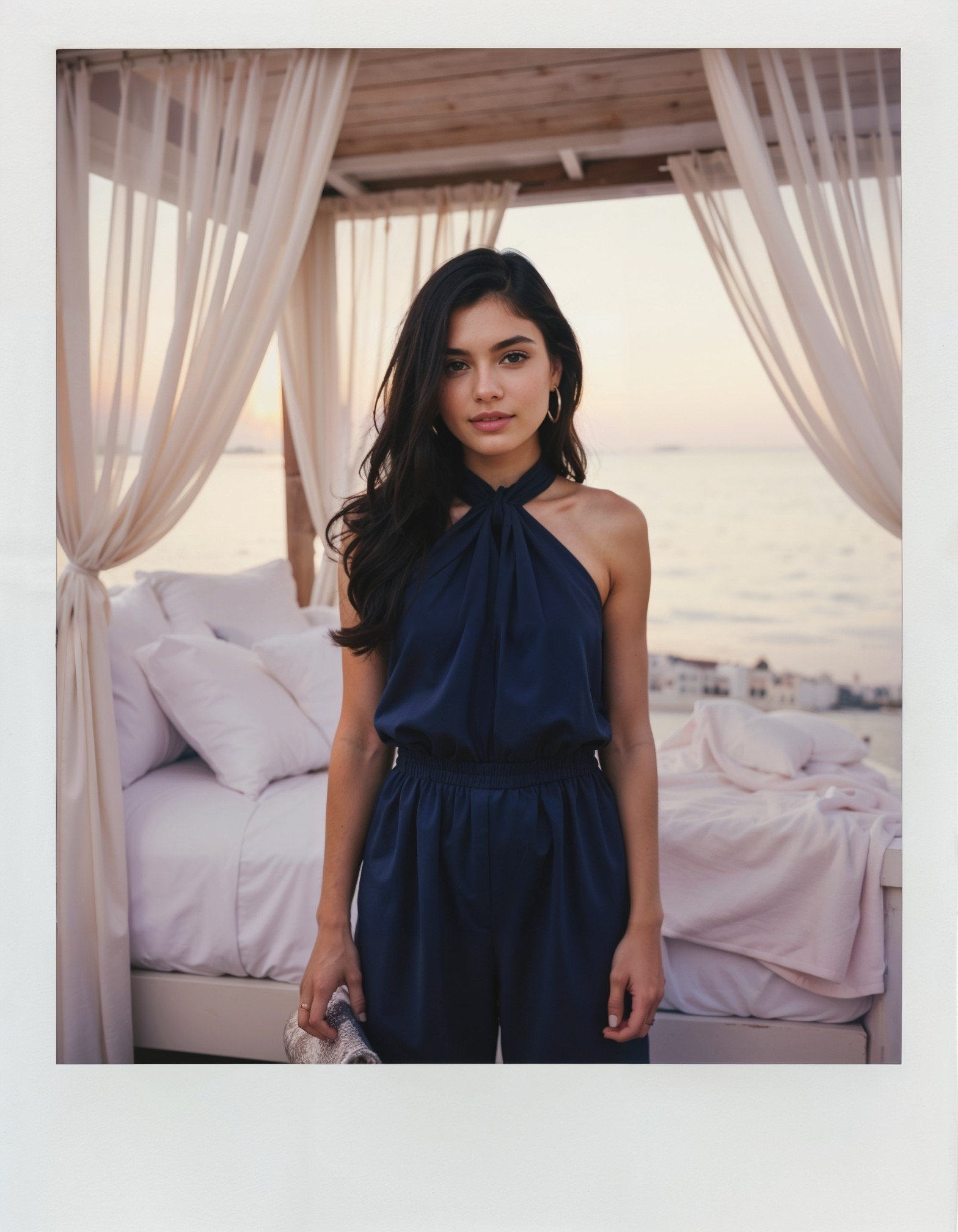 a polaroid photo of a woman wearing Chic navy blue jumpsuit with a halter neckline, cinched waist, and wide-legged trousers, accessorized with a metallic clutch in a Romantic seaside suite with a white linen canopy bed, flowing curtains, and the soft glow of twilight in the style of maripol, 19-years-old, (medium perky breasts, soft body, puffy nipples, conical nipples:1.2)<lora:maripol-flux1-dev-v1-000088.safetensors:1.2> <lora:Petite_body_type_for_FLUX.safetensors:0.5> <lora:FLUX.1-Turbo-Alpha.safetensors:1.0>