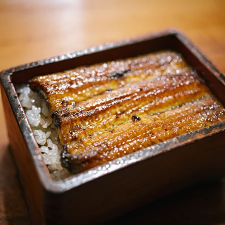 raw photography,film photography,film grain,close-up,unajyu on table,wood table,<lora:Unajyu:1>
