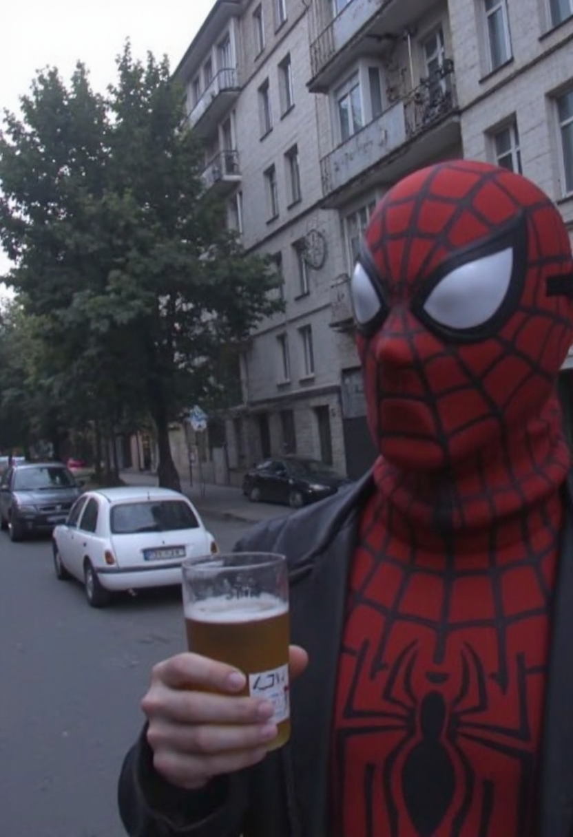 d1g1cam, Spiderman with mask drinks beer, in 2000s early, Dull and overcast lighting, his face partially shadowed, amateur photo, low-lit, Low-resolution photo, shot on a mobile phone, evening, noticeable noise in dark areas, he is standing on the street near soviet-era storey buildings, trees, parked cars near, outdoors