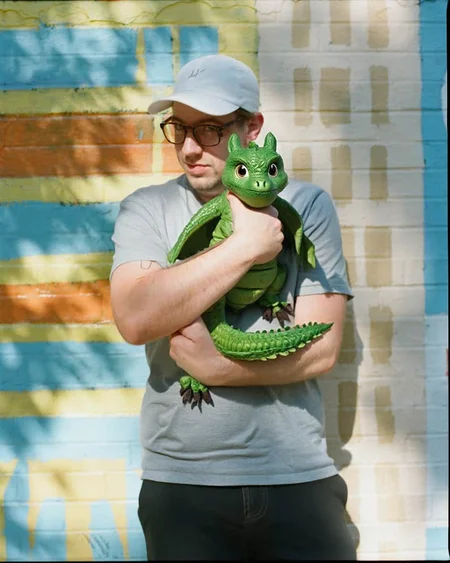 A man with standing in front of a colorful striped wall, upper body photo, he is holding a baby green dragon, the dragon is a fantastical fantasy cute beast that spits fire and have scales, folded wings and big eyes, the background is a vibrant outdoor setting with a striped wall in shades of blue, green, and yellow.
ðï¸ [Inpainted with Loras]: flux1-canny-dev-lora
ð¯<lora:syml\lorasym\Flux\flux1-canny-dev-lora.safetensors:0.75:0.75>
