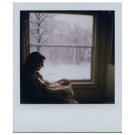 polaroid of A mother, cradling a newborn, looking out the window as the first snow of winter falls gently.  <lora:Polaroid_XL:1>