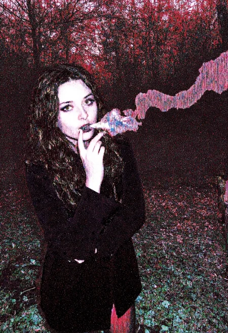 Circuit-bent/glitch art photograph showing a young woman in her early 20s with a casual style wearing a dark trench coat, long wavy brown hair cascading over her shoulders, looking directly at the viewer with gothic heavy makeup, standing outdoors in a dark forest during autumn, lit cigarette between her lips with smoke rising, sunlight filtering through the trees creating dappled light patterns, background includes dense trees and scattered fallen leaves, vertical glitch streaks, red and teal color shifts, pixelation effects and wave-like distortion patterns, extreem digital corruption level