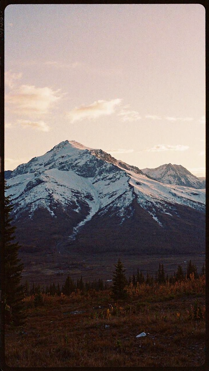 8n8log, Evening photo of an Alaskan mountainscape. Evening, long shadows, dusk <lora:GrainScape_1404698:1> , film photography aesthetic, film grain effect prominent throughout image, grainy film-like textureâââ