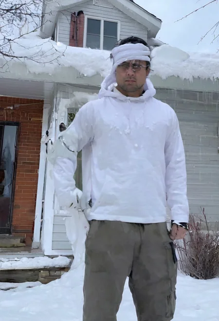 Stable_Yogis_SD1.5_Positives, patherpcook Stands in front of a House, Male, Strong, Flexing, Snow on head, Toga, Pondering, White house, Siding, walkway, driveway,