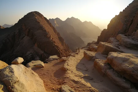 Atop Mount Sinai in Egypt, where jagged stone ridges glow in the desert light and ancient paths wind between peaks. At high winter midday with wind, (flickering stone heat:1.1) dances along the ridges, birds ride thermals, and stillness dominates. ,