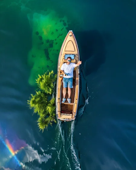 vertical perspective aerial photography,highres,clear face,realistic,in summer,round lake,Rainbow Lake,lying on a boat,