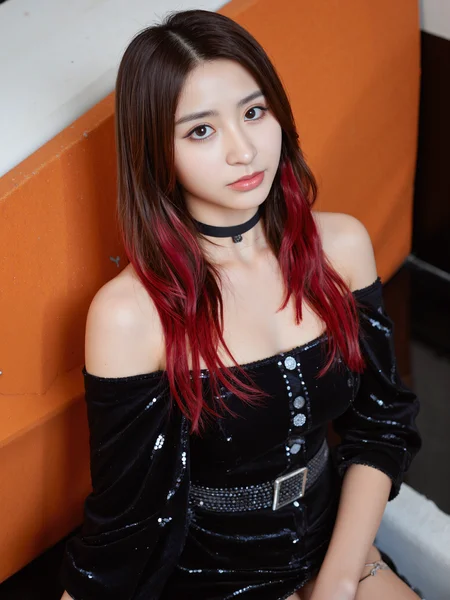 This is a high-resolution photograph featuring a young Asian woman with striking red and black hair, styled in loose waves cascading over her shoulders. She has a fair skin tone and delicate, symmetrical features, with a touch of makeup accentuating her eyes and lips. She is wearing a black, off-the-shoulder dress adorned with sparkling sequins, adding a glamorous touch. The dress has a high neckline and a belt with a square buckle at the waist, highlighting her slim figure. She wears a black choker and a headset, suggesting she might be a cosplayer or an actress in character. The background features a geometric pattern with warm orange and white hues, adding depth and contrast to the image. The lighting is soft, creating a gentle glow that enhances the texture of her dress and the lustrous quality of her hair. The camera angle is slightly low, looking up at her, which adds a sense of intimacy and focus to her face. The composition uses the rule of thirds, with her face and upper body positioned in the upper third, drawing the viewer's eye naturally across the image. The overall style is modern and stylish, with a hint of fantasy due to her elaborate attire.