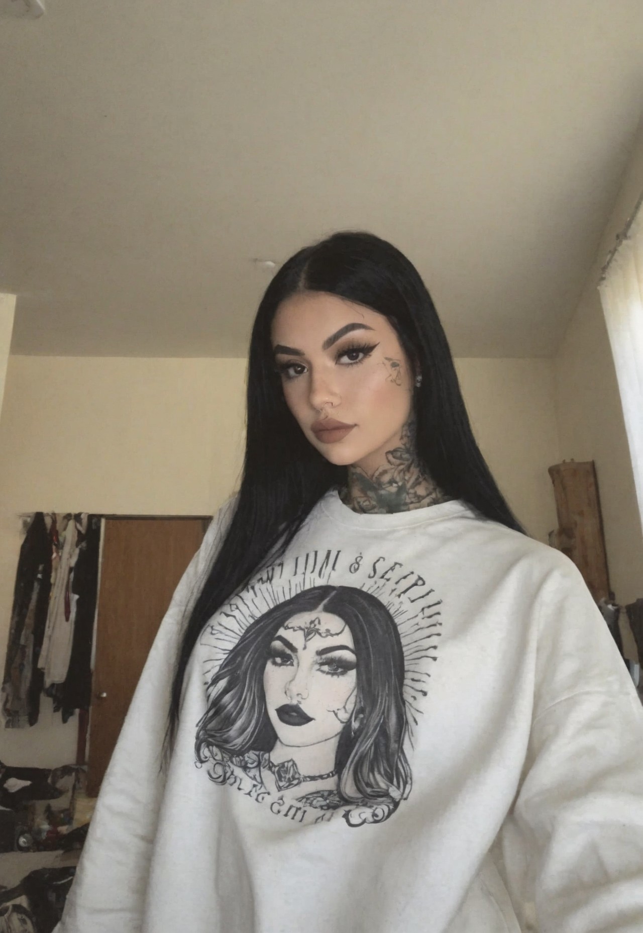 film grain, instagram model, egirl, 1girl, tanned_skin, latina, (dressed), very long hair, black_hair, tattoo, tattooed, sweatshirt, apartment, room, no light, close up, portrait, masterpiece, best quality, (ultra-detailed), absurdres, very aesthetic, newest, 2025, latest, amtr2, photo taken