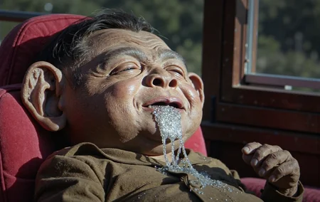 North Korean Juche Socialist propaganda, The Dear Respected Comrade General Secretary Grand Marshall of the People's Army Supreme Leader Kim Jong-UNukie the knockoff alien is passed out giggling in his sleep, drooling magical metal flake sparkle saliva all over himself, inspired by the workers, conceived by the Mount Paektu bloodline