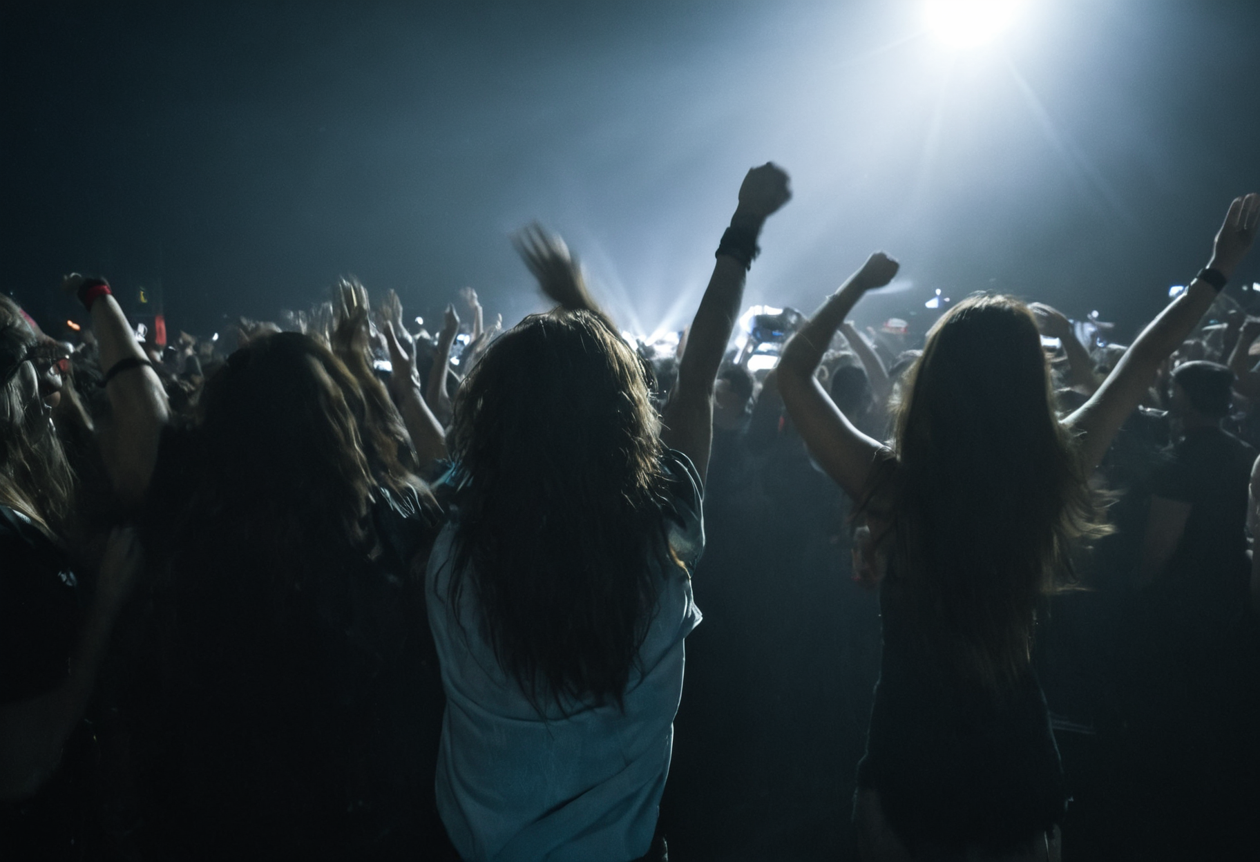 photo of three fans at a rock concert standing in a crowd, cheering, detailed skin, long hair, dark, direct artificial light, motion blurr <lora:mobile:0.8>