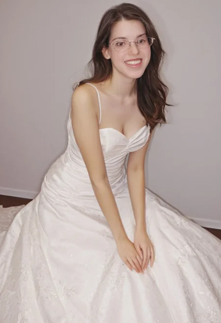 realistic photo of Beautiful young woman, perfect medium perky natural breasts, 2009 style, low rise, low contrast style, 8mm film, analog photography style, long brown hair, sharp facial features,thick nerdy glasses, pale white skin, , influencer, brown eyes, no makeup, instagram, detailed skin texture, detailed eyes, detailed face, slim, (small waist, wide hips, thick thighs:1.2), (sexy wedding gown with pink highlights:2.0), happy, smiling, juicy ass,