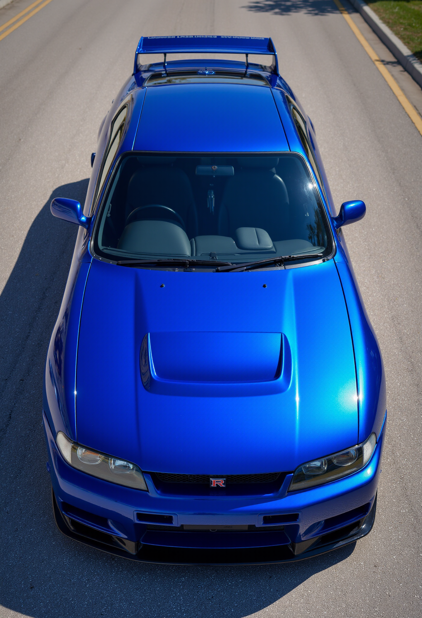 <lora:Nissan_Skyline_GT-R_R33:0.7> A slightly from above eye level of a gorgeous Nissan Skyline GT-R R33 in all its shining glory. In a style of clean look. The car has blue paint job with purple undertone. Mirror-like, high gloss finish catches bright highlights. Vibrant color palette.