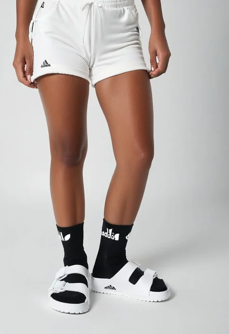photorealistic, masterpiece, best quality.
1girl, solo, simple_background, white_background, standing.
calves, thighs, adidas_shorts, lower_body, slippers, footwear_focus, scksnsndls, birksonsocks, black_socks.
