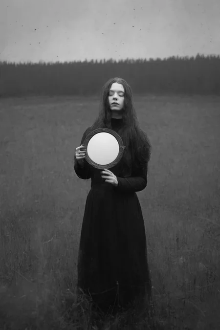 <lora:Photographer Maren Klemp Style:1>Photographer Maren Klemp Style - a black and white photo of a person holding a mirror in a field