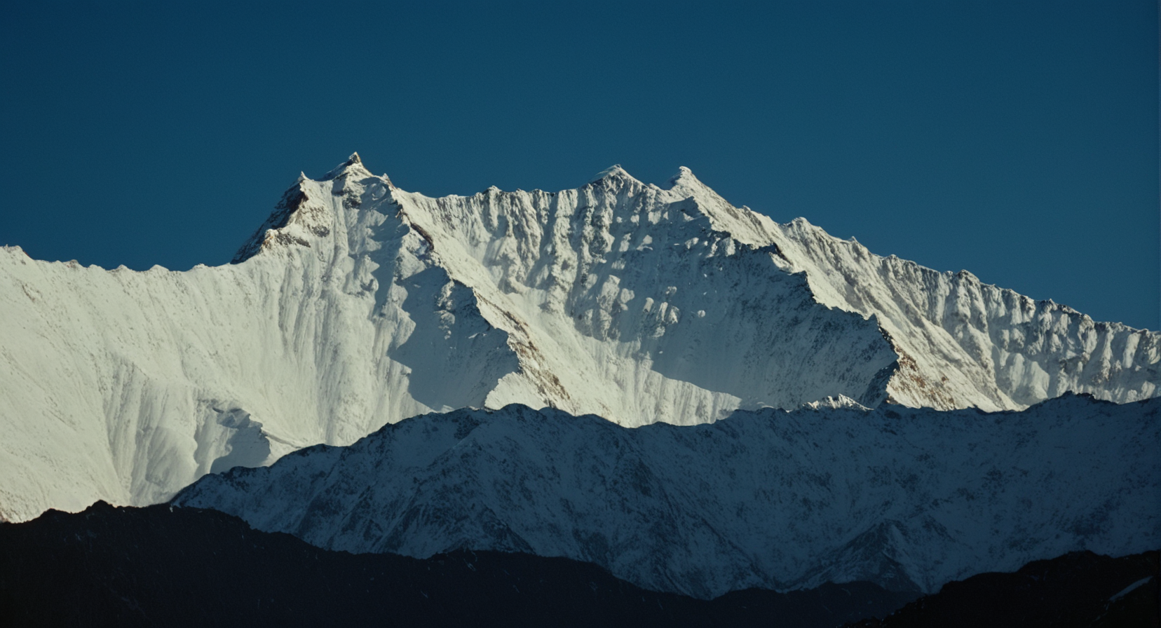 cinematic film still of  <lora:Ron Fricke style:1>
a mountain range with a snow covered mountain in the background,outdoors,sky,day,blue sky,no humans,scenery,snow,mountain,landscape,mountainous horizon , realistic, realism, movie still, film grain, kodak film, film contrast, film color, cinematography, documentary, photography, 70 mm film, 65 mm film, Todd-AO, Todd-AO 35, 8K resolution, Ron Fricke film director style, Ron Fricke film directing style, Ron Fricke style, shallow depth of field, vignette, highly detailed, high budget, bokeh, cinemascope, moody, epic, gorgeous, film grain, grainy