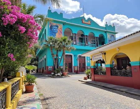 In a vibrant Caribbean city, the colorful street teems with life under the brilliant glow of a warm sun, casting playful shadows on the cobblestone pathway. The architecture that lines the street is a fascinating blend of tropical flair and communist-inspired design, featuring bold, angular shapes with bright, eye-catching murals depicting revolutionary figures and lush, wild landscapes. As you gaze down the bustling thoroughfare, your eyes are drawn to the imposing government building at the street's end. Its façade is painted in an uplifting shade of turquoise, adorned with ornate columns that stand tall and proud against the cerulean sky, while the sunlit reflections shimmer like jewels on the surface. The pervasive scent of salty ocean air mingles with the sweet aroma of tropical flowers blooming in vibrant bursts of pink and orange, creating a feast for the senses. Towering palm trees sway gently in the soft, tropical breeze, their fronds whispering secrets overhead as locals and tourists alike stroll by. Lively chatter fills the air, punctuated by the distant sounds of music spilling out from a nearby café, where the rhythmic strumming of a guitar blends seamlessly with the rhythmic laughter of friends gathered around vibrant, mosaic-tiled tables. Above, the bright blue sky stretches endlessly, dotted with fluffy white clouds, encapsulating the essence of a perfect Caribbean day, where warmth, color, and the spirit of community seamlessly intertwine in a harmonious celebration of life
  <lora:amateurphoto-6version:1>   <lora:Dark Cinematic:1> DRK