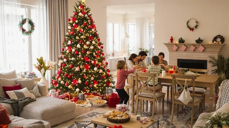 Christmas Tree with Gifts in a Decorated Living Room with Cookies and a Family Around a Dining Table with Christmas Food 4k