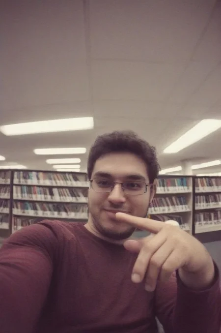 man sitting in library taking a selfie, badquality, low quality <lora:badquality_v02:1>