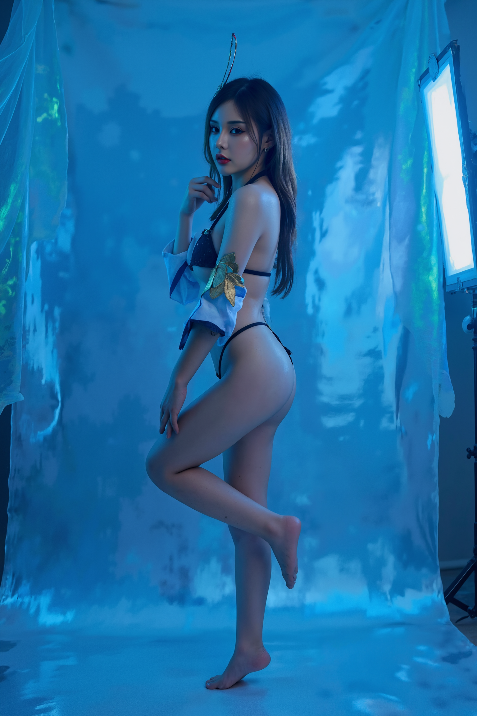 This is a high-resolution professional full body photograph featuring a young woman is posed in a standing contrapposto stance, with subtle weight shifted to one leg to create a natural S-curve in the body silhouette. This classic posing technique creates visual interest and a sense of elegance.

She is wearing SGWN41ClothingStyle2.

The lighting features a high-contrast, monochromatic blue color scheme that creates a moody, intimate atmosphere. 

The photography technique uses what appears to be soft lighting to create a glamorous effect, with careful attention to highlighting contours while maintaining the dominant blue color scheme throughout the frame.

The overall aesthetic combines elements of fashion photography, traditional Asian visual motifs, and contemporary boudoir styling. The dramatic blue lighting creates a cohesive visual theme that ties all elements of the composition together.

The white light coming from the camera direction highlighting the subject feature.
