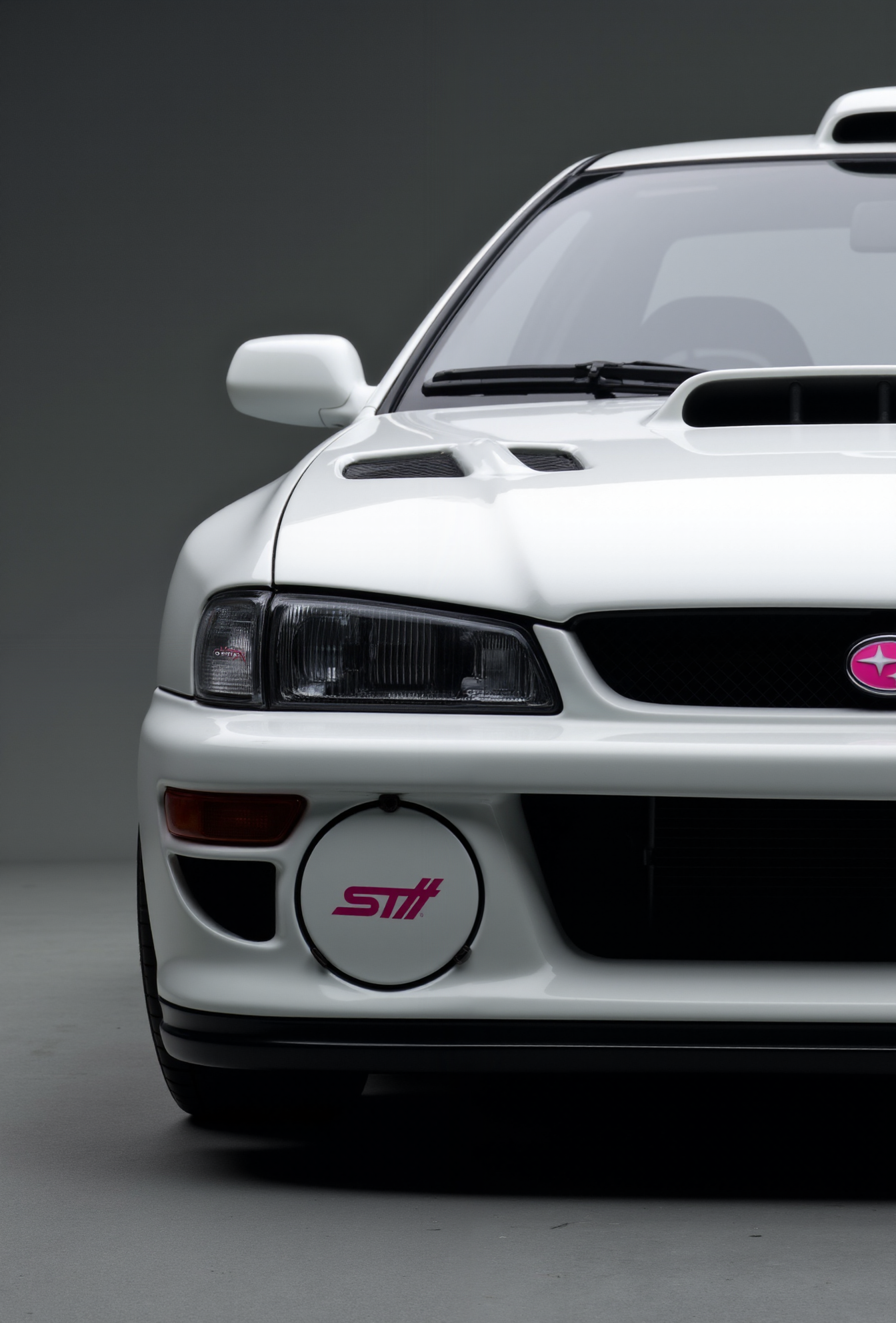 <lora:Subaru_Impreza_WRX_STI_22b:0.8>
A close-up shot of a white Subaru Impreza WRX STI 22B rendered in hyper-stylized realism with heavy body modifications, including wide fenders, deep front splitter, aggressive white hood scoop, and rally-inspired venting. Captured in frontal view against a dark neutral gradient backdrop, carbon fiber aero elements, and red highlights on grille Subaru badge and round fog cover inserts with pink on white STI badge. The headlamps are sharp and crystal-clear, casting tight reflections over the satin white paint. Studio lighting isolates the car with strong rim lighting and soft floor bounce, creating a stylized motorsport profile framed in cinematic ultra-high contrast realism.