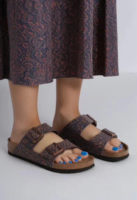 1girl, solo, simple_background, white_background, birksonfeet, blue_toenail_polish, close-up, lower_body, footwear_focus, patterned, long_skirt