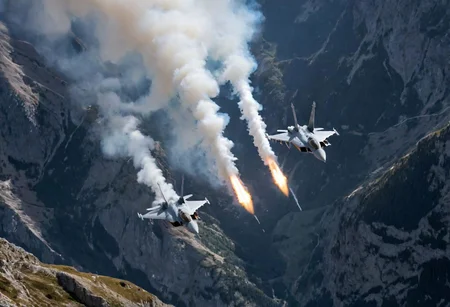 (Pilots flying the Euro Fighter jets between mountains), (displaying the low level flying capabilities of the Euro Fighter jets), hitting amazing speeds as the tilt and wind through the valleys and canyons, (view from side of euro fighter jets), (launching missiles with a stream of white vapors with flames), (a true display of military might power), (motion scenes), (pain staking attention to fine details of the jets) ,4k, surreal, (epic photography),