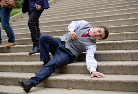 a casual photo where a dapperly dressed average superhero with Down syndrome is Falling down the stairs in public. No watermark, no signature.