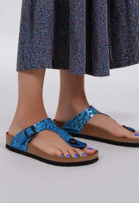 1girl, solo, dynamic_pose, simple_background, white_background, gizehonfeet, blue_toenail_polish, close-up, lower_body, footwear_focus, patterned, long_skirt