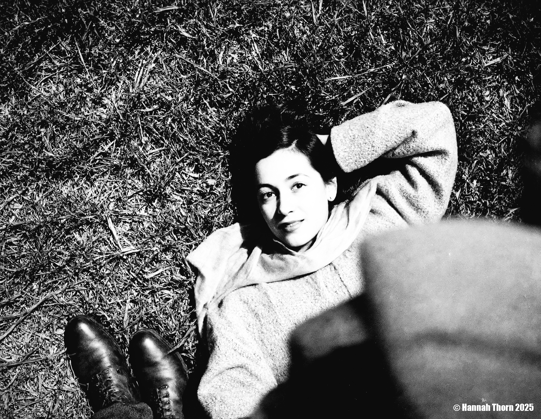 A black and white photo from a bird's eye view about a woman lying on the grass, looking directly at the viewer with a contemplative expression. the subject, a woman with light skin and dark hair, is lying on her back in the center of the image, wearing a knitted sweater and a scarf around her neck. she has a slim body and is positioned in the middle of the frame, with her head resting on her hand. her expression is serene and contemplative, with a hint of a smile on her lips. she is wearing a pair of brown boots on her feet, and her dark hair is styled in a way that frames her face. the background is a patch of grass, and the lighting is soft and natural, casting gentle shadows on her face and body. the overall mood is peaceful and intimate, creating a sense of calmness and tranquility.<lora:_Flux\Saul_Leiter_BW.safetensors:1.0:1.0>