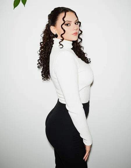 Dafne Keen a woman in a black suit posing for a picture against a white background. She is wearing a black pants, white turtleneck, with long curly hair with dark eyeliner and mascara. <lora:Dafne_Keen:1.4> <lora:dmd2-sdxl-4step:1>