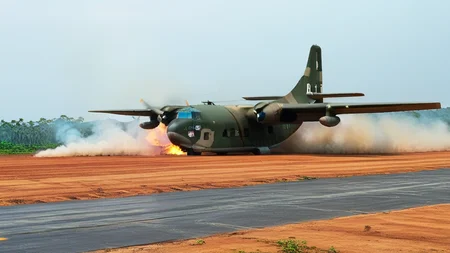 cinematic movie still of USAF (AIR_C123:2) landing on a dirt airstrip, engine on fire, viet nam, jungle in background, smoke and fire in the distance, hyperdetailed, shallow depth of field, f1.4, <lora:AC_C123:1>