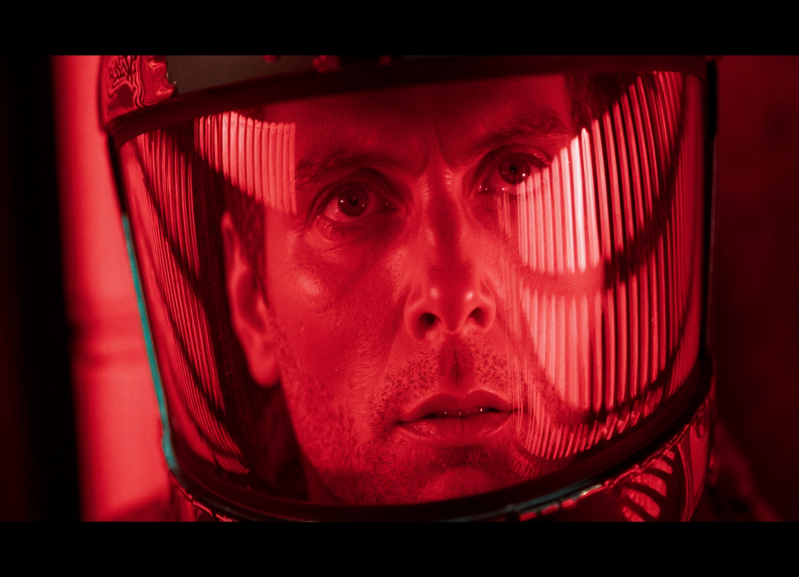cinematic film still A close-up of a person's face, partially obscured by a transparent helmet. The helmet emits a bright red light, creating a stark contrast against the dark background. The person's eyes are wide open, and their expression is contemplative. The image has a cinematic style, emphasizing the interplay of light and shadow. The color palette consists primarily of deep reds and blacks, with the helmet's reflective surface adding depth and dimension . shallow depth of field, vignette, highly detailed, high budget, bokeh, cinemascope, moody, epic, gorgeous, film grain, grainy