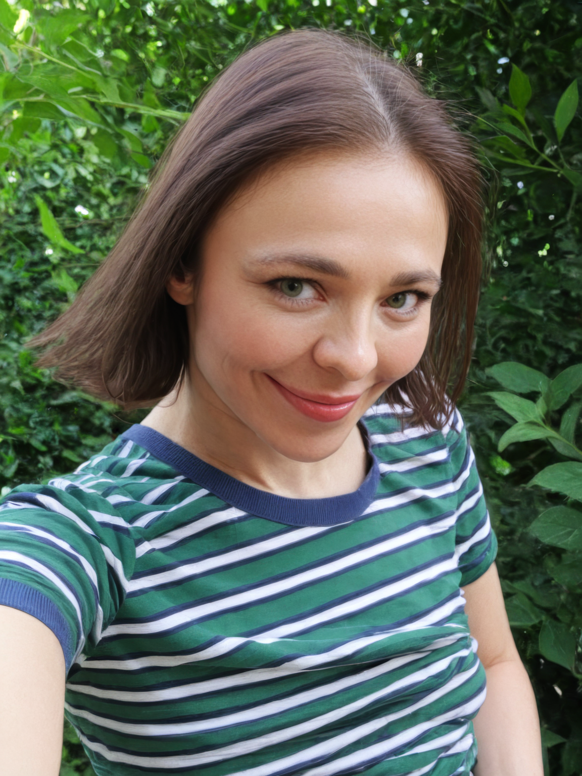 nina_kraviz, photograph, striped shirt, smiling, green foliage, natural light, casual, candid, cheerful expression