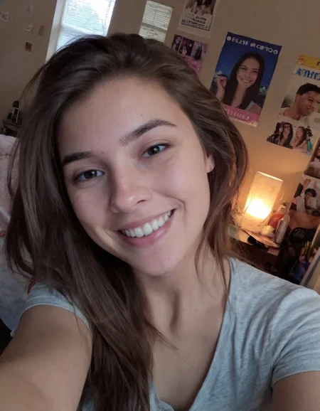 Authentic share, Amateur quality phone photo, A young woman taking a selfie with her phone, typical of a 2015 Snapchat post. She is smiling casually, with minimal makeup, in a casual setting like her bedroom. The lighting is soft and natural, coming from a window, and the background shows some personal items like posters and a bed