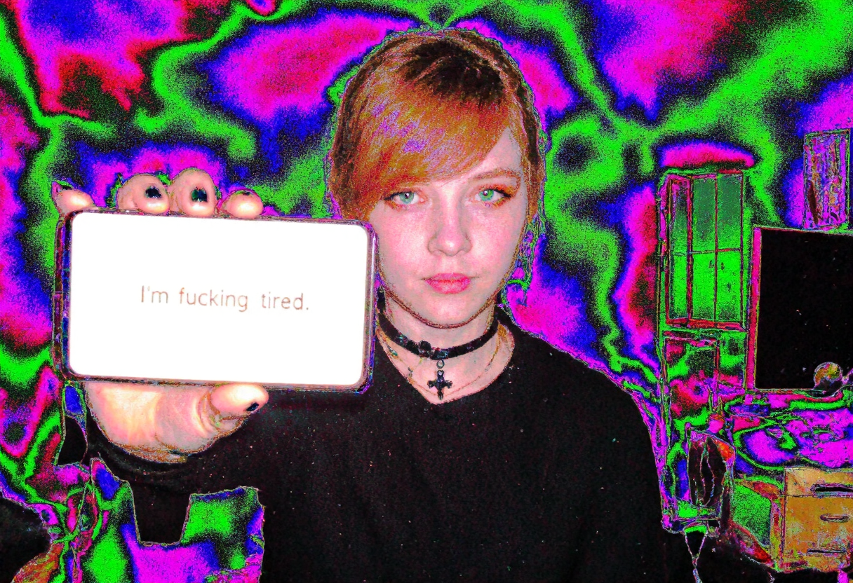 Circuit-bent/glitch art photograph showing a young woman, early 20s, easter european, fair skin, reddish-brown hair pulled back, side-swept bangs covering part of the forehead, dark eyeliner, orange eyeshadow, natural lip color, She also has a black choker and a black cross necklace. Her expression is neutral. room with furnitures and desk with computer and monitor and window. holding Samsung note10 with bright illuminated display to viewer, display showing text "I'm fucking tired". She has black nailpolish and rings on some fingers. artificial indoor heavy light, low light condition, underexposed face, face slightly shadowed, daytime. bright multicolored textures dominating the subject, wave-like color distortions, vivid neon color shifts with predominant green blue and magenta hues, distinct pixelation and edge artifacts, overall high digital corruption level