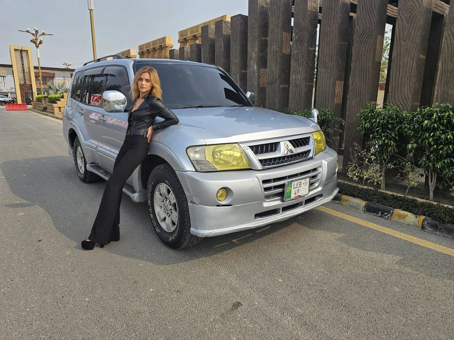 a close-up face of a beutiful woman leaning on a car