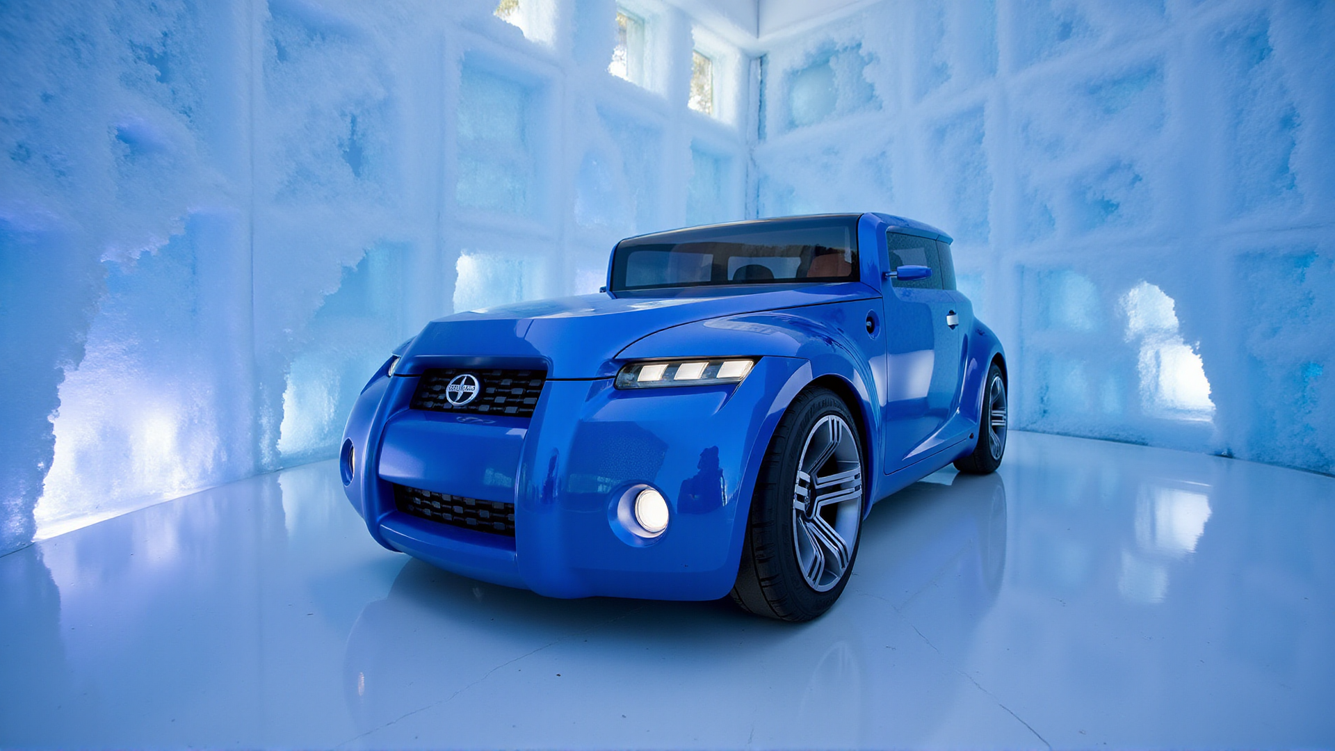 The Scion Hako Coupe Concept inside a vast ice cave, surrounded by jagged, reflective ice walls. The carâs livery is a shimmering sapphire blue, with frosty patterns etched along its body. The close-up focuses on the circular fog lights and wheel arches, with the ice walls amplifying the carâs futuristic lines through distorted reflections. A soft glow from embedded LEDs in the ice creates a magical and pristine atmosphere
 <lora:ral-hkcpcncpt_000004000:1>
