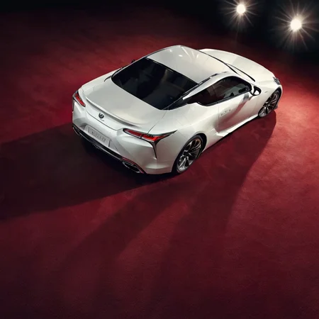 realistic photo of a white lexuslc car on a red carpet, spotlight, cinematic, from behind, <lora:LexusLC_SDXL_v1:1>