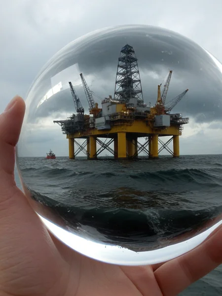 Closeup, [North Sea Oil Platform, wild sea], William Turner, London storm, inside a transparent faceted reflective plastic sphere on the palm of a hand