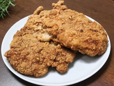 A high-resolution, hyper-realistic image of a deliciously fried chicken cutlet, referred to as G8G. The G8G is golden brown, with a crispy, crumbly coating and tender, juicy meat inside. It's served on a rustic wooden plate, with a side of fresh, colorful vegetables and a dollop of tangy sauce. The scene is set in a cozy, homely kitchen, with all elements in sharp focus, creating a clear and detailed image. The lighting should be warm and inviting, highlighting the appetizing qualities of the G8 and the cozy atmosphere of the setting, <lora:g8:0.7>