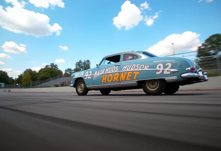 This is the Hudson Hornet, an American passenger car manufactured in 1951.from side.low angle.A panning shot of a car racing around a circuit.. <lora:hudson-hornet:0.8>,