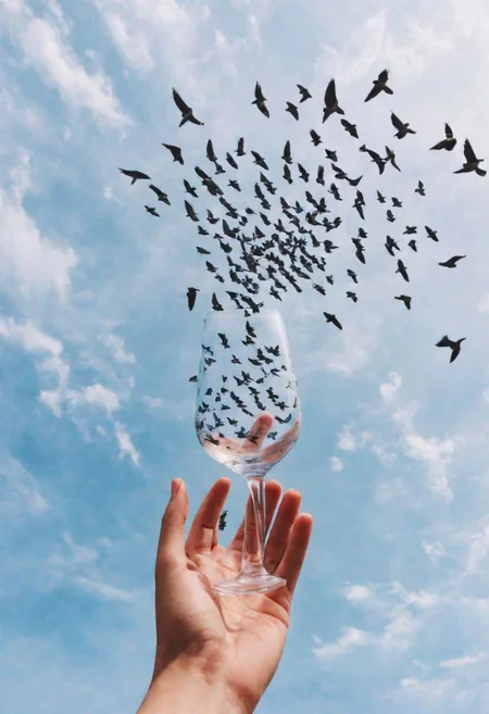F-B-C, POV, foreground: one hand holding a glass  , background: a flock of birds in the sky , effect: birds are catched in a glass