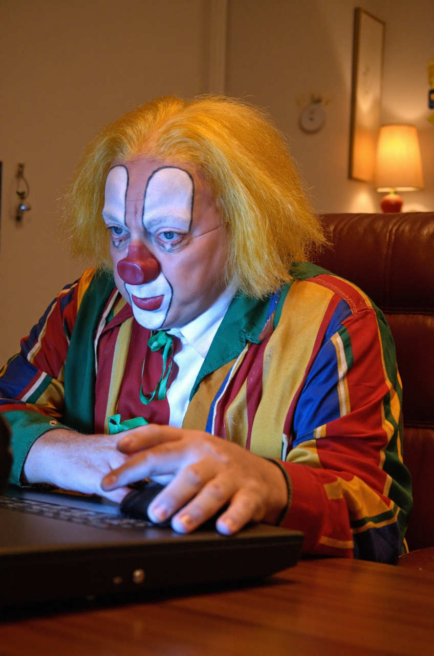 <lora:Bassie:1.6> Bassie the clown, A person browsing the internet, clicking a mouse, and looking at the viewer curiously.