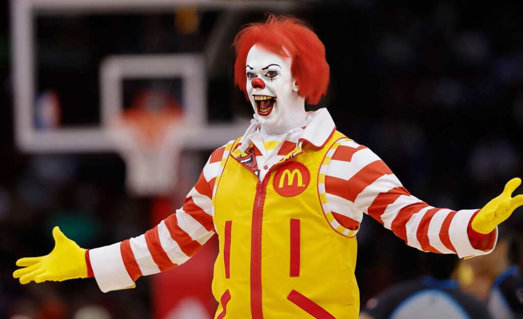 Pennywise1024, a man dressed in a mcdonald's costume is performing a trick for the crowd at a basketball game, Darrell Riche, hyper realistic face, a stock photo, hyperrealism  <lora:Pennywise1024-000420:0.8>