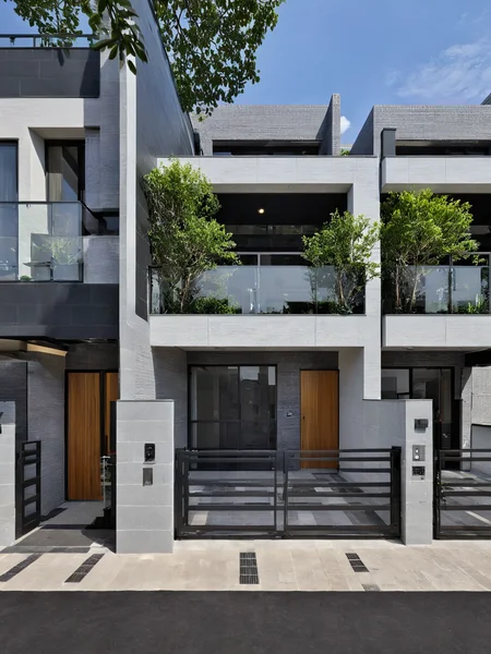 Architectural style, <lora:JJsRowHouse_XL:1>,(masterpiece) , (best quality), ((RowHouse)), dramatic lighting, high quality outdoors, sky, day, cloud, tree, blue sky, building, scenery, road, real world location, sunlight, enough detail, high resolution,super realistic, Photorealistic, highly detailed, balcony, plants, door, gate, paving, . Clean lines, geometric shapes, minimalist, modern, architectural drawing, highly detailed