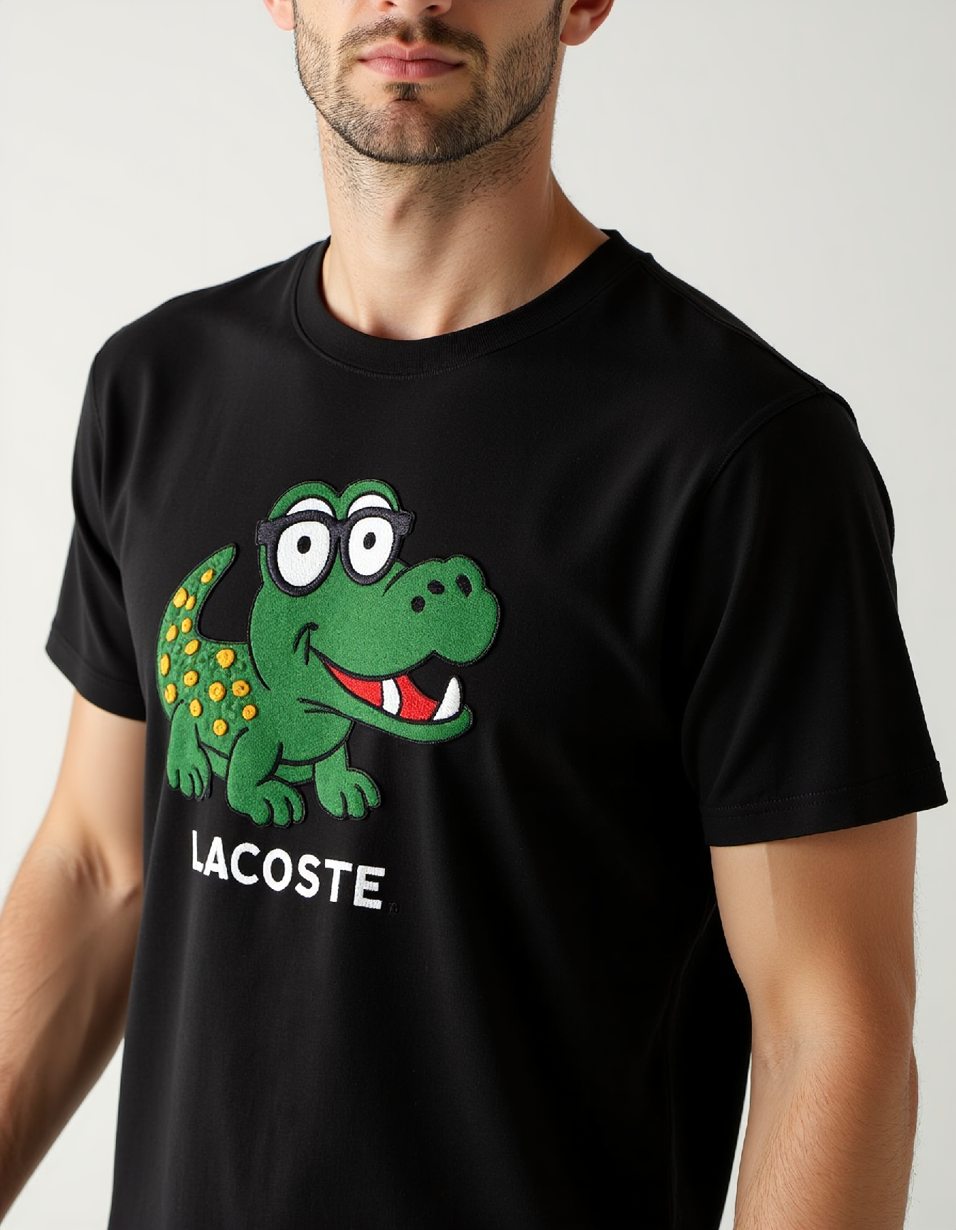 aplqueCE_style. a man wearing a black t-shirt with a large applique of a cute crocodile wearing a glasses and text:"Lacoste".
