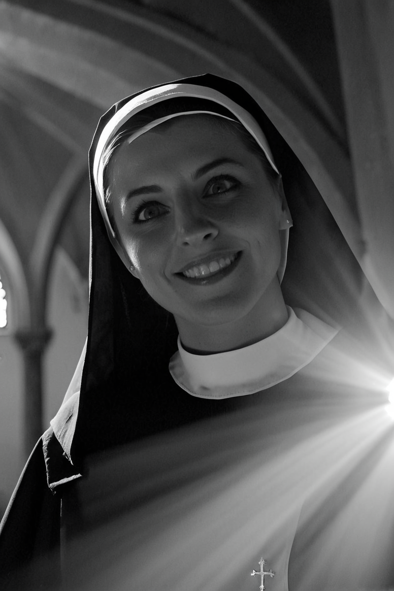 <lora:Emma_Corrin_SDXL_101:0.8> emmacorrin101 1girl cinematic photo looking at viewer as a  nun in church ,smiling expression, , finely detailed eyes, epic scene, epic composition, Photography, Cinematic Lighting, Volumetric Lighting, ethereal light, intricate details, extremely detailed volumetric rays 35mm photograph, film, bokeh, professional, 4k, highly detailed . Bleak, post-apocalyptic, somber, dramatic, highly detailed